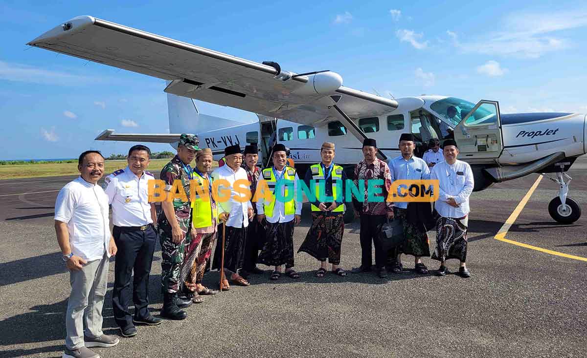 Prof Dr KH Asep Saifuddin Chalim, MA bersama rombongan foto bersama dengan latar belakang pesawat Susi Air di lapangan terbang Harun Thohir Bawean, Gresik, Jawa Timur, Jumat (26/5/2023). Foto: BANGSAONLINE