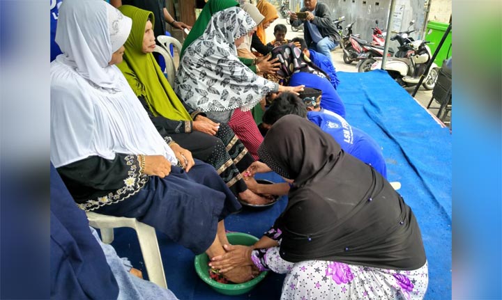 Anak-anak sedang membasuh kaki ibu saat HUT LSM FPSR. foto: SYUHUD/ BANGSAONLINE
