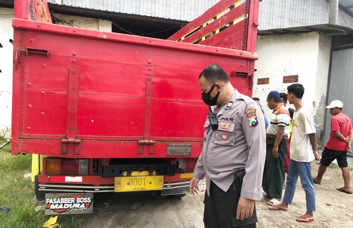 Petugas sedang menunjukkan bagian belakang truk yang ditabrak korban.