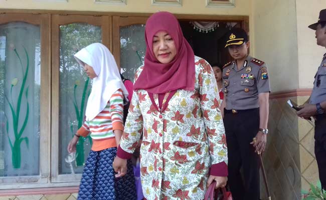 MALU: Korban Vina Ridaul Vahali memakai jilbab putih bersama ketua PKK dan Kapolres saat hendak dibawa ke RS untuk keperluan visum.? foto: EKY NURHADI/ BANGSAONLINE