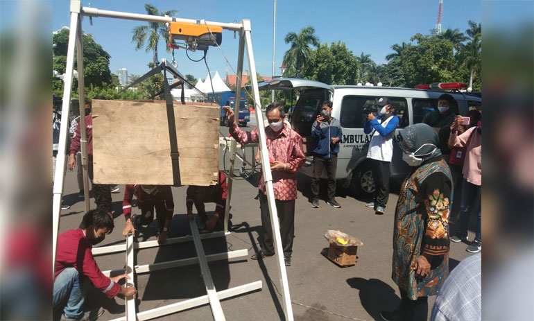 Rektor IT Telkom Surabaya Tri Arif Sarjono sedang menjelaskan dan mendemokan Crane Pemulasaran Jenazah Otomatis kepada Wali Kota Risma.