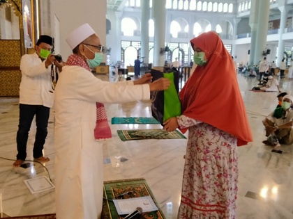  Arneta Chandra Angelina Putri, milenial yang baru masuk Islam menerima cindera mata dari KH Abdul Halim, Imam Masjid Nasional Al-Akbar Surabaya, Jumat (3/4/2020). foto: MA/ BANGSAONLINE