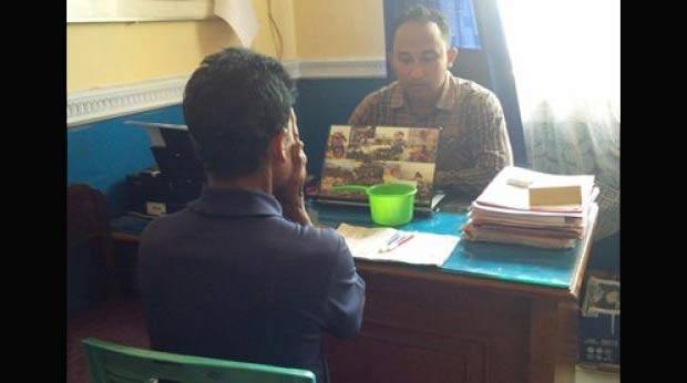 Tersangka saat disidik di kantor polisi. 