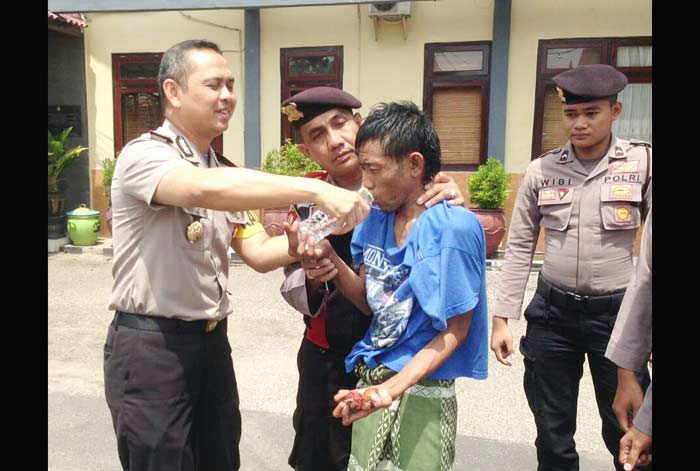 Kapolres Pamekasan memberikan minum pada salah seorang orgil yang diamankan.