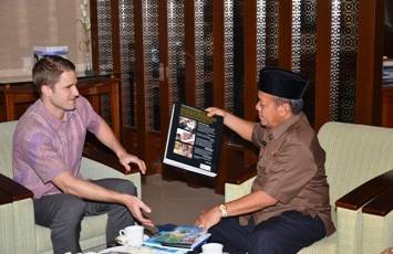 Kepala Bagian Politik dan Ekonomi Konsulat Jenderal (Konjen) Amerika Serikat (AS) di Surabaya, Brandon C, saat memberikan buku tentang AS ke Bupati Lamongan, Fadeli. (foto: haris/BANGSAONLINE)