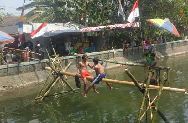 Salah satu peserta lomba gebpuk bantal saat berduel. (foto: dendi martoni/BANGSAONLINE)
