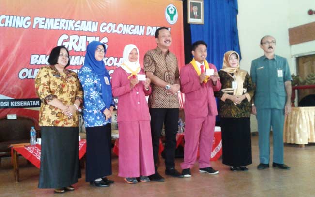 Bupati Ipong Muchlissoni bersama pelajar yang membawa kartu golongan darah. 