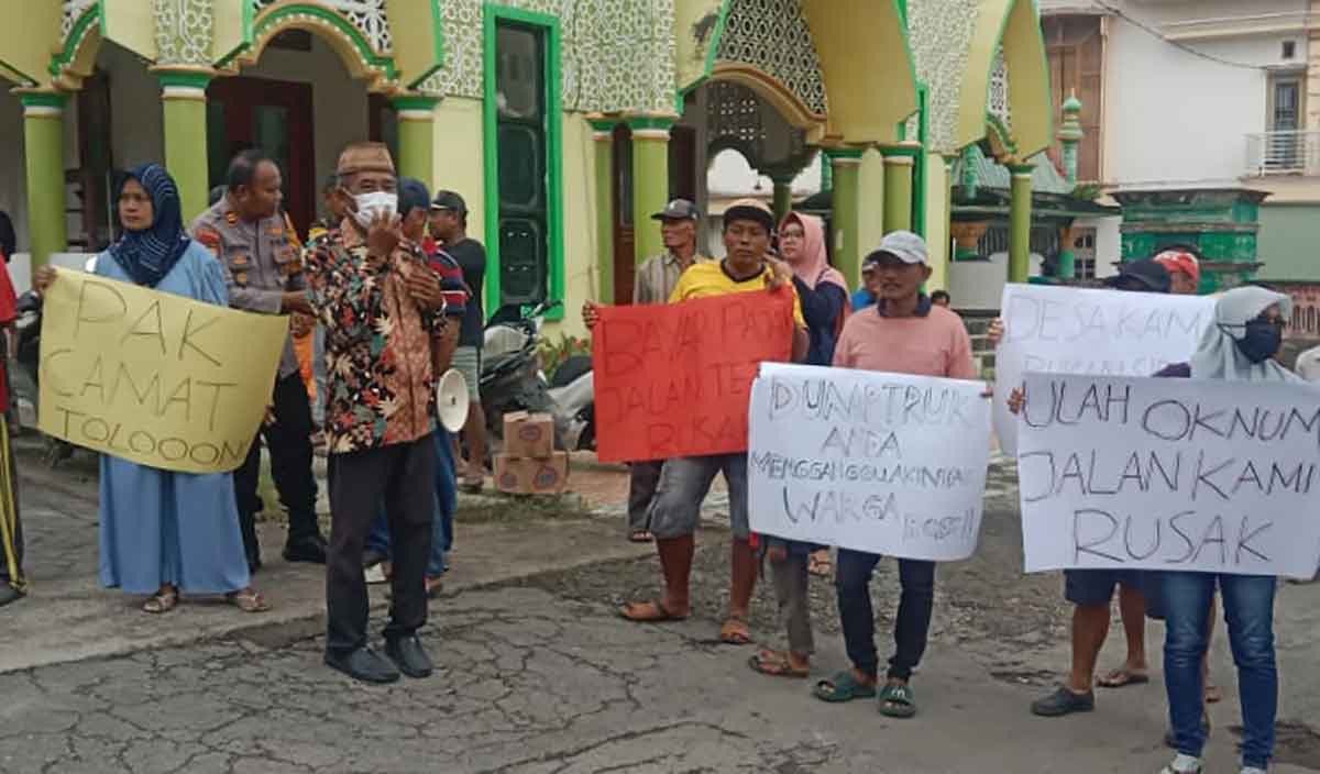 Warga Desa Delegan, Kecamatan Panceng, Gresik, saat membawa poster ketika demo jalan rusak. Foto: Ist