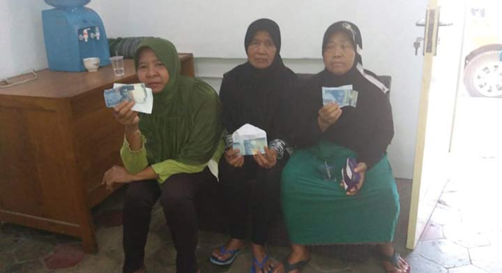 Emak-emak saat menunjukan barang bukti money politics di kantor Bawaslu Banyuwangi.