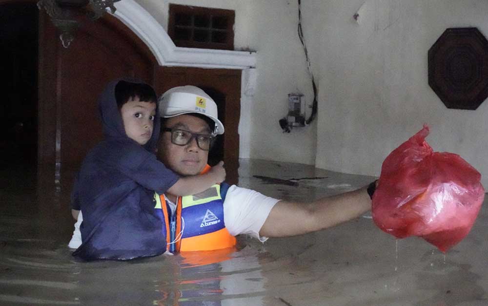 Direktur Utama PLN Prasodjo (kanan) ketika mengevakuasi seorang anak yang rumahnya terkena banjir di Perumahan Nasional 1 Kayuringin Jaya, Bekasi, Jawa Barat, Selasa (4/3/2025).
