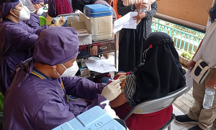 Petugas saat menyuntikkan vaksin kepada salah satu siswi SMKN 3 Kota Kediri. (foto: ist)