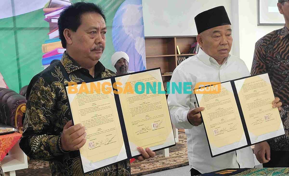 Prof Dr KH Asep Saifuddin Chalim, MA dan Muhammad Syarif Bando menunjukkan MoU Amanatul Ummah dan Perpusnas di Masjid Kampus KH Abdul Chalim Kampus IKHAC Pacet Mojokerto, Rabu (19/7/2023). Foto: M Mas