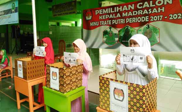 Siswa MINU Trate Gresik memasukkan surat suara. foto: SYUHUD/ BANGSAONLINE