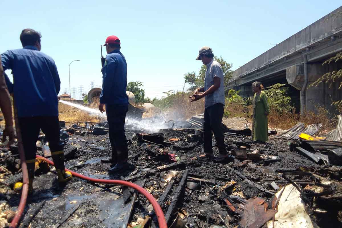 Petugas Damkar dari Pos Waru dan Buduran saat melakukan pemadaman api pada bangunan semi permanen di bawah Tol Kedungturi Sidoarjo, Selasa (12/9/2023).