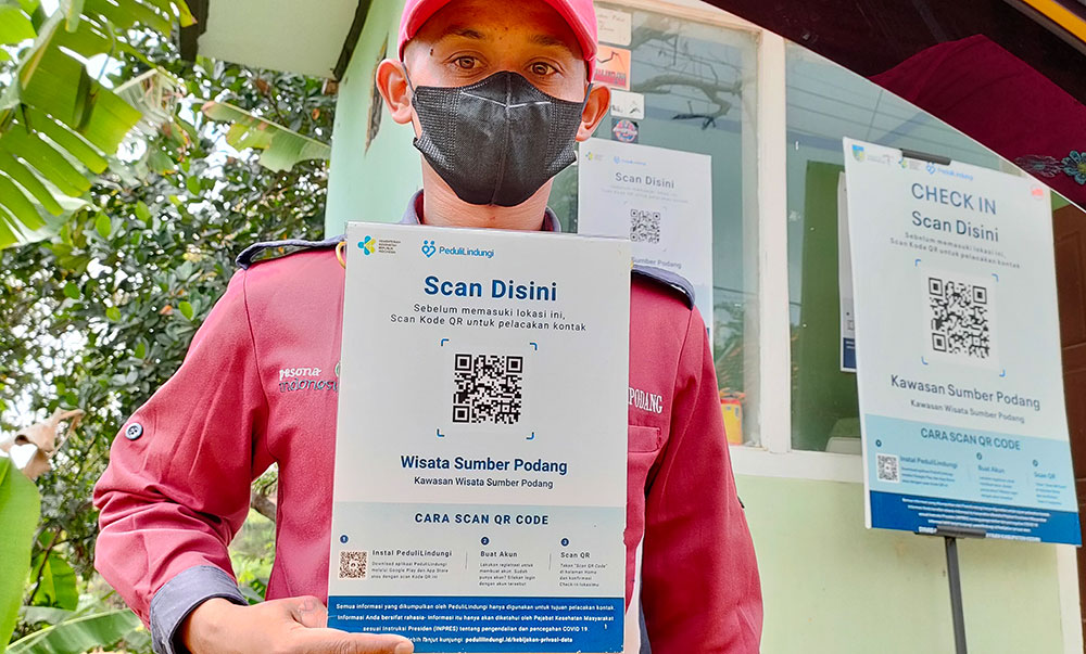 Petugas jaga di pintu masuk kawasan wisata Sumber Podang, Desa Joho, Kecamatan Semen, Kabupaten Kediri, siap dengan aplikasi PeduliLindungi. Foto: MUJI HARJITA/ BANGSAONLINE