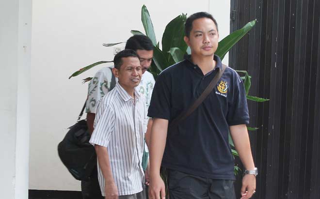 Tersangka Sugeng Mujiadi (tengah), eks Dirut PDAM Sidoarjo saat akan memasuki mobil untuk kembali dijebloskan ke tahanan. foto: NANANG ICHWAN/ BANGSAONLINE