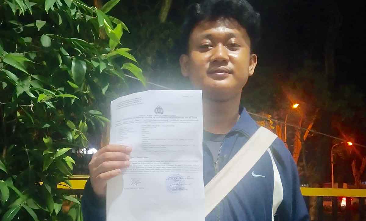 Seorang mahasiswa Unitomo saat menunjukkan laporan polisi usai dikeroyok kelompok pesilat.