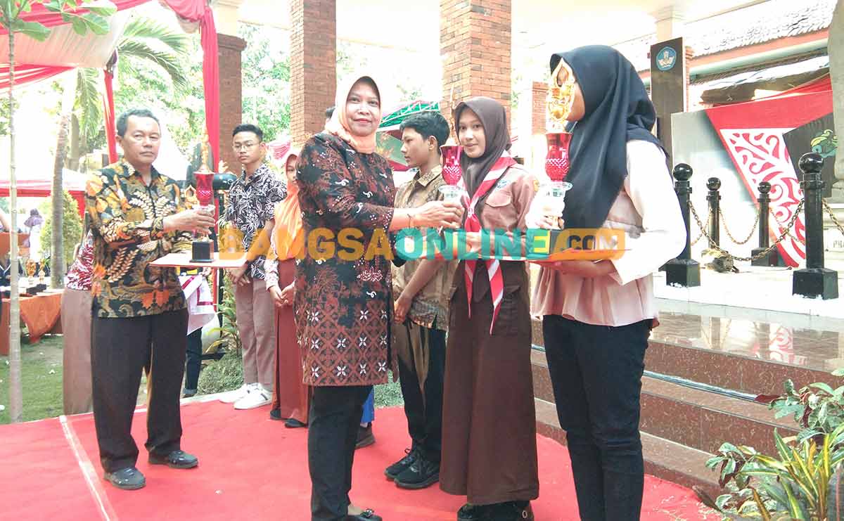 Kepala Disporabudpar Nganjuk, Sri Handariningsih, saat menyerahkan piala dan piagam kepada pemenang lomba olimpiade sejarah. Foto: BAMBANG DWI JULIANTO/BANGSAONLINE