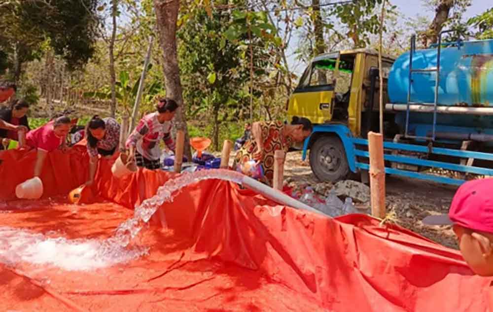 Warga Bojonegoro terdampak kekeringan sedang mengambil air bersih yang didistribusikan BPBD.