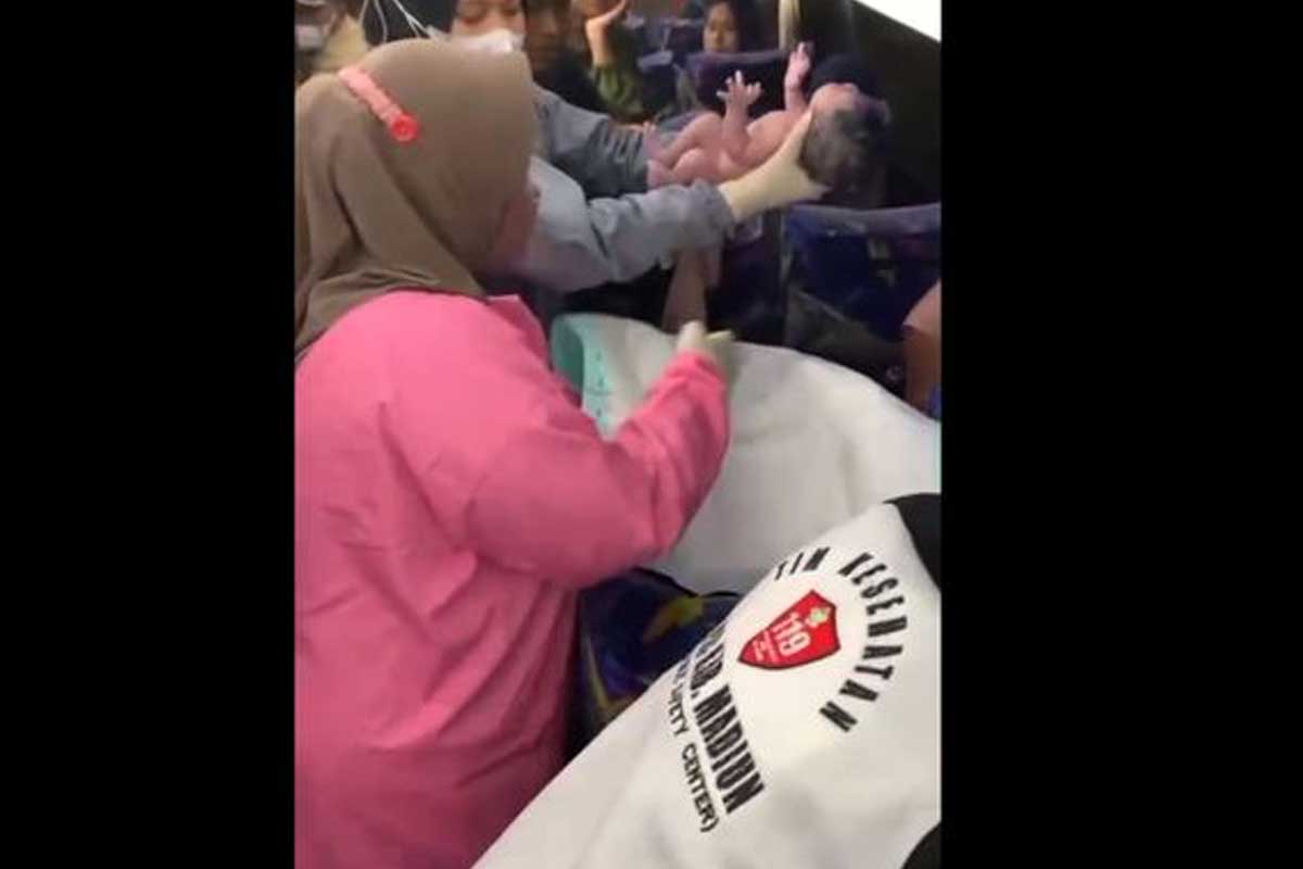 Salah satu petugas PSC 119 saat menggendong bayi yang telah dilahirkan oleh pemudik asal Bangkalan, Fadilah.