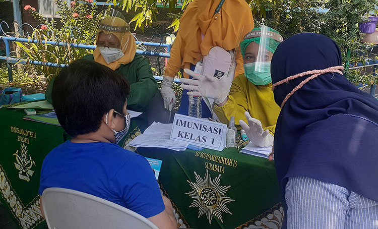 Petugas puskesmas pasca memberikan imunisasi MR pada siswa kelas 1 SDM Limas. (foto: ist)