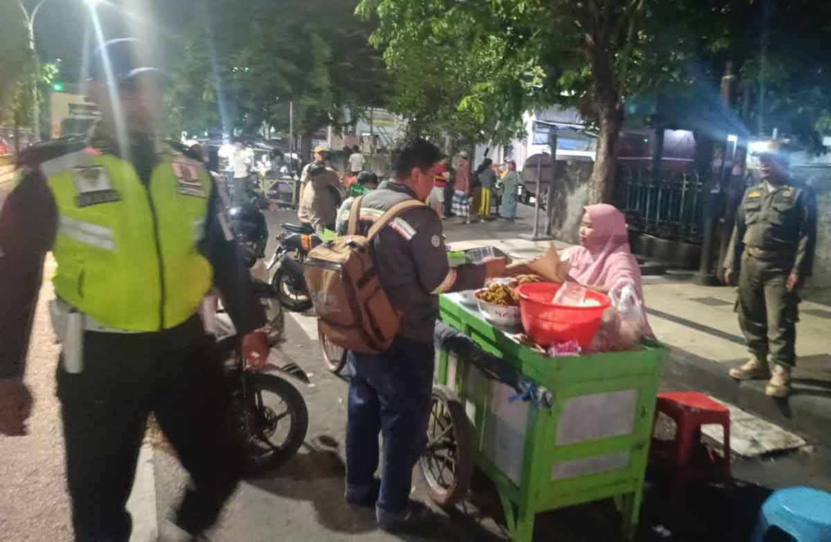 Petugas saat menertibkan pedagang yang berjualan di bahu jalan depan Pasar Baru Gresik. Foto: Ist
