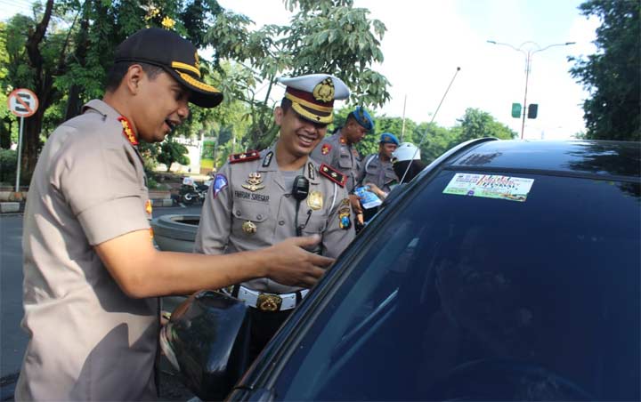 Kapolresta Sidoarjo Kombespol Zain Dwi Nugroho memasang sticker ajakan tertib berlalu lintas di mobil yang melintas.