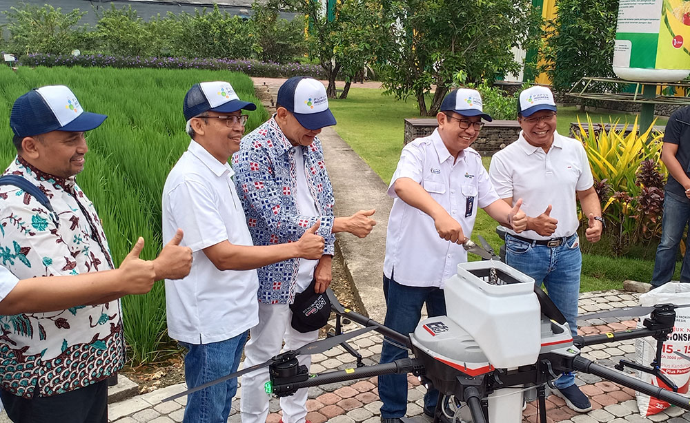 Dirut Petrokimia Gresik Dwi Satriyo Annurogo, dan Chairman MarkPlus Inc Hermawan Kartajaya secara bergantian mengisi pupuk dalam tabung ukuran sekitar 25 liter di mesin drone sebelum diterbangkan. foto: SYUHUD/ BANGSAONLINE