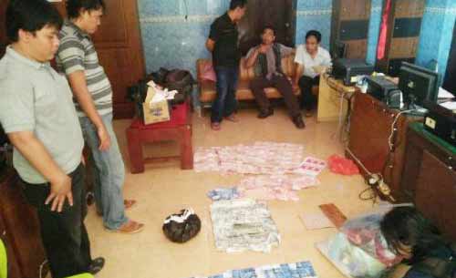 HITUNG: Petugas kepolisian menghitung jumlah upal yang diproduksi di rumah kos, di Desa Plandi, Jombang Kota.