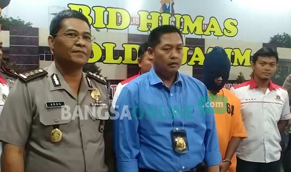 Pelaku didampingi Kombes Pol Nurrochman (tengah), Dirreskrimsus Polda Jatim dan Kabid Humas Polda Jatim Argo Yuwono (kiri). foto: sidharta/ BANGSAONLINE