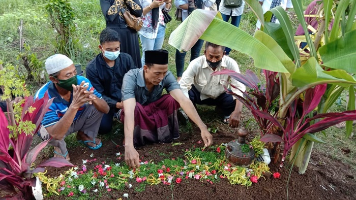 Hariyanto, ayah korban sedang berdoa di pusara putri bungsunya di makam Desa Kabat.