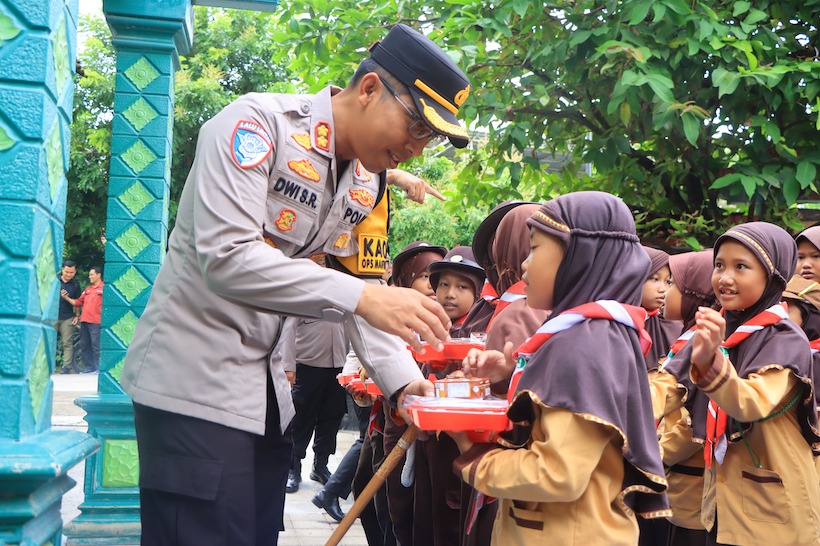 Kapolres Ngawi saat memberi paket makan siang bergizi gratis kepada salah satu siswa