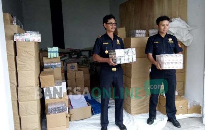Petugas menunjukkan rokok ilegal yang berhasil disita Kantor Pengawasan dan Pelayanan Bea Cukai Tipe Pratama Blitar. foto: AKINA/ BANGSAONLINE