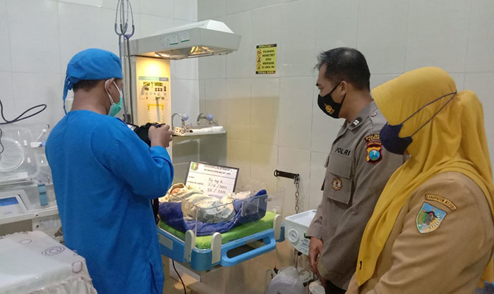 Kapolsek Ringinrejo, Iptu Joko Suparno, dan petugas medis saat memandangi bayi setelah tiba di rumah sakit. Foto: Ist