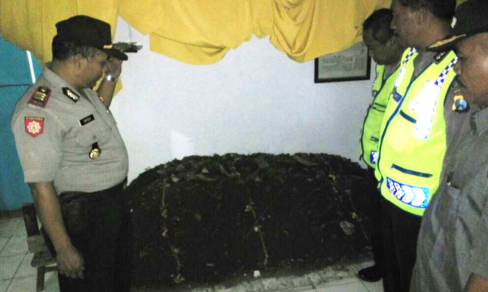 Kapolsek Prambon, AKP Satuji, saat meninjau lokasi pemakaman di dalam rumah.