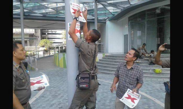 Petugas saat menyegel Marvell City, Selasa (17/5).