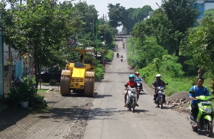 Petugas saat melakukan perbaikan jalan di Desa Sumbergedang, Pandaan.

