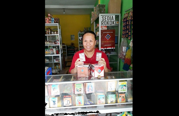 Endah Yuliani atau Cik Iin saat menunjukan rokok kesehatan di warung jamunya.
