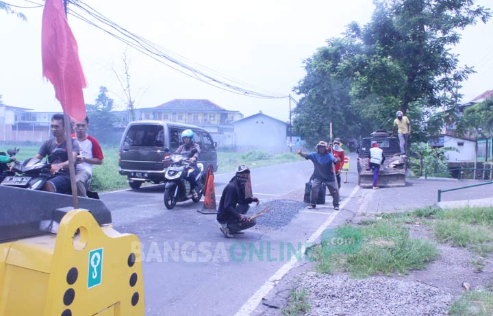 Perbaikan di salah satu ruas jalan yang rusak.