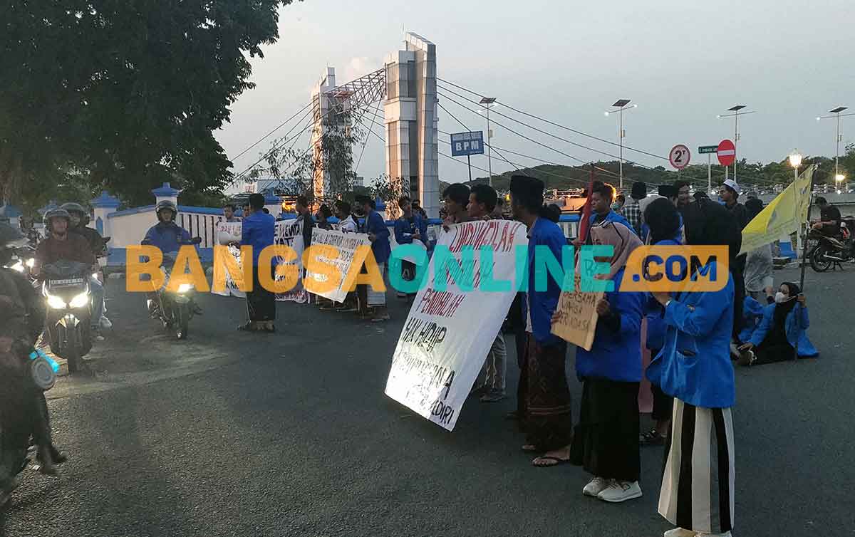 Para mahasiswa yang tergabung dalam PMII Kediri saat berorasi di pinggir jalan dan menutup sisi barat Jembatan Brantas Lama. Foto: MUJI HARJITA/BANGSAONLINE