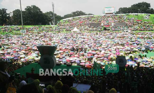 Puluhan Ribu Muslimat NU tak goyah meski panas matahari menyengat. Mereka berteduh di balik payung masing-masing di Stadion Gajayana, Malang, Jawa Timur. foto: BANGSAONLINE