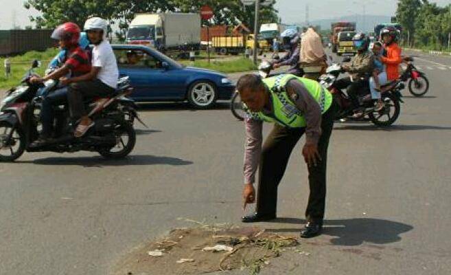 Petugas dari Unit Laka Lantas Polsek Porong menunjukkan lokasi tabrakan karena menerobos TL. foto: nanang ichwan/ BANGSAONLINE