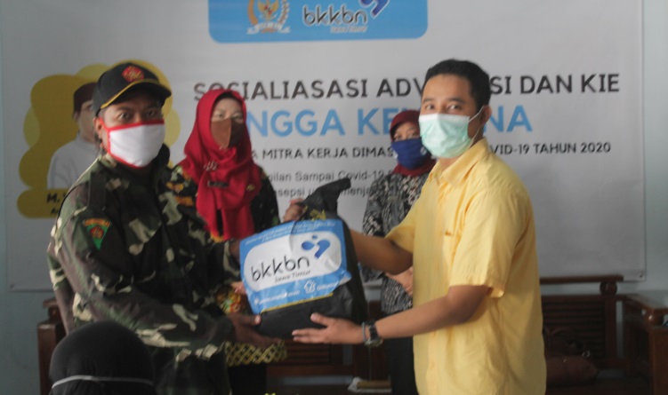 Anggota Komisi IX DPR RI melalui Staf Ahli Noor Fuadi saat memberikan sembako secara simbolis pada kegiatan sosialisasi BKKBN.