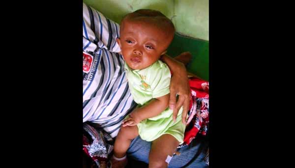 Afrizal dalam gendongan ibunya. foto: soewandito/ BANGSAONLINE