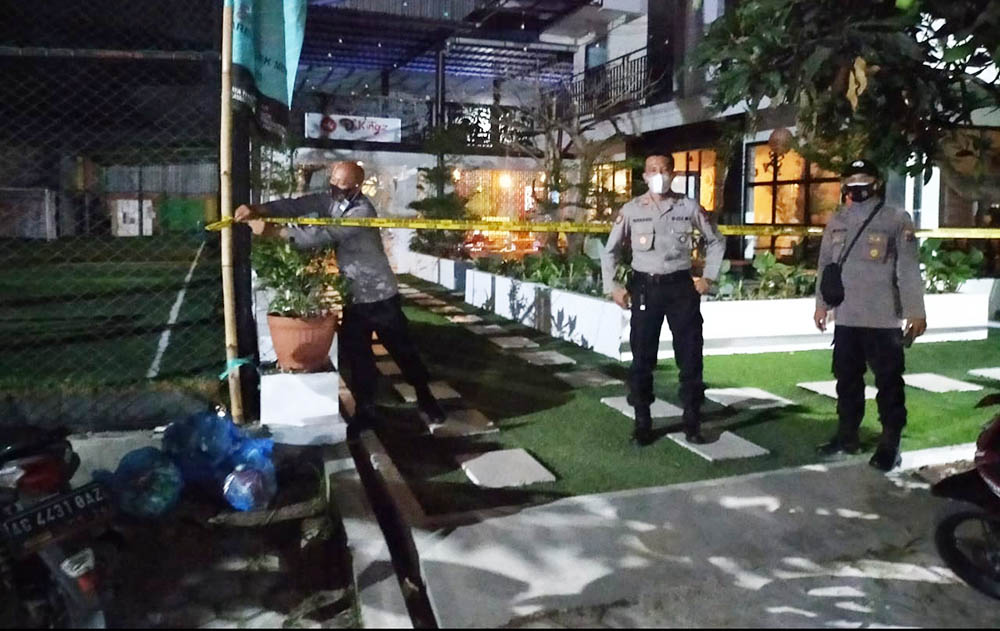 Petugas memasang garis polisi terhadap salah satu cafe di Kecamatan Kanigoro karena beroperasi melanggar jam malam selama PPKM Darurat.