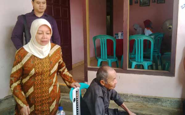 Haryanti saat membantu dengan memeriksa kondisi kesehatan salah satu pasien di Desa Petungroto Kecamatan Mojo, Kabupaten Kediri. foto: arif kurniawan/BANGSAONLINE