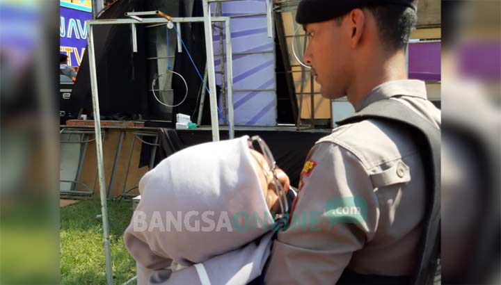 Salah satu penonton perempuan yang pingsan dibopong oleh petugas.