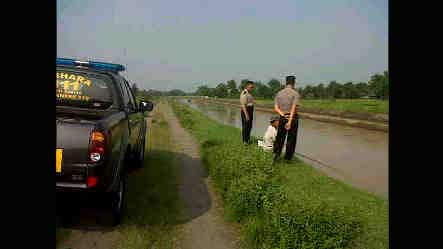 Polisi saat melakukan olah TKP di pinggir sungai, lokasi yang menewaskan seorang santri. foto: dendi martoni/ BANGSAONLINE