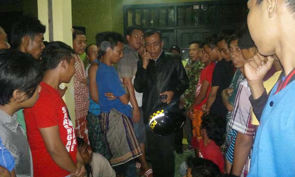 Massa berjaga di depan rumah salah satu tokoh agama untuk menyelamatkan penjambret dari massa yang emosi. Nampak petugas yang kesulitan mengevakuasi pelaku penjambretan, kemarin. foto: khumaidi/BANGSAONLINE