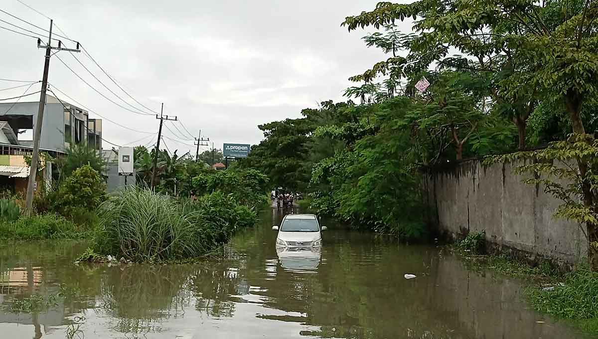 Mobil jenis Toyota Inova Nopol L 1906 ZG yang terjebak banjir di Jalan Mutiara 2.8 No. AM-1, Desa Mulung, Kecamatan Driyorejo, Gresik. Foto: Ist